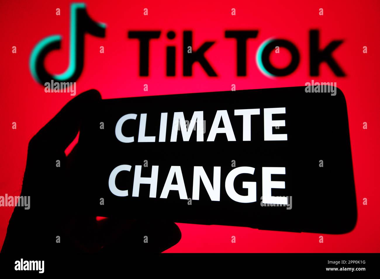 In questa immagine, le parole "cambiamento climatico" sono visualizzate su uno smartphone e il logo TikTok sullo schermo di un pc. Foto Stock