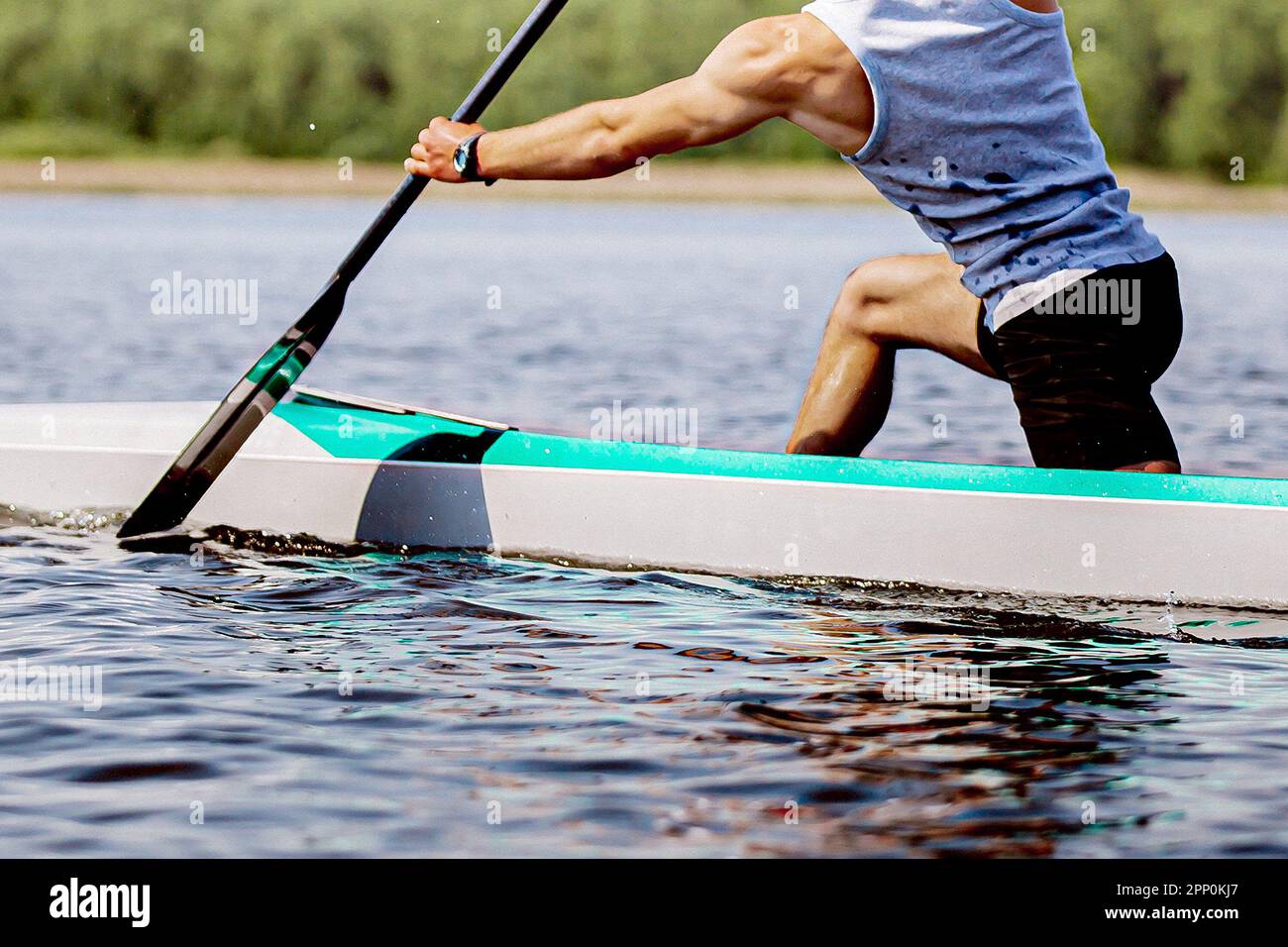 primo piano parte corpo maschio canoista su canoa singolo vogatore allenamento sul lago, braccio muscolare per tenere pagaia Foto Stock