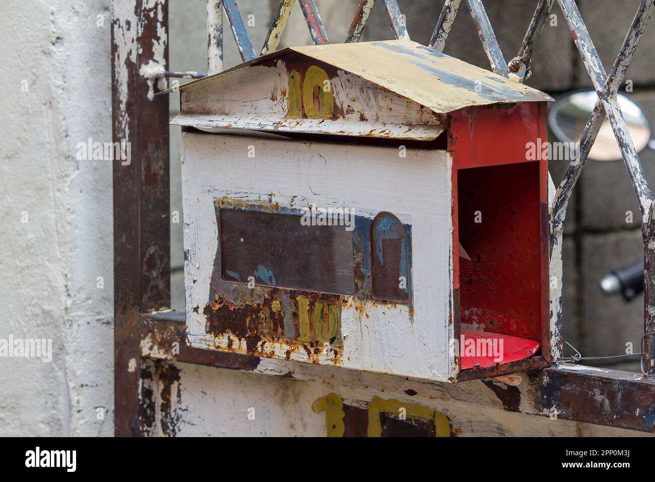 La vecchia cassetta postale bianca era appesa alla recinzione di ferro. Foto Stock