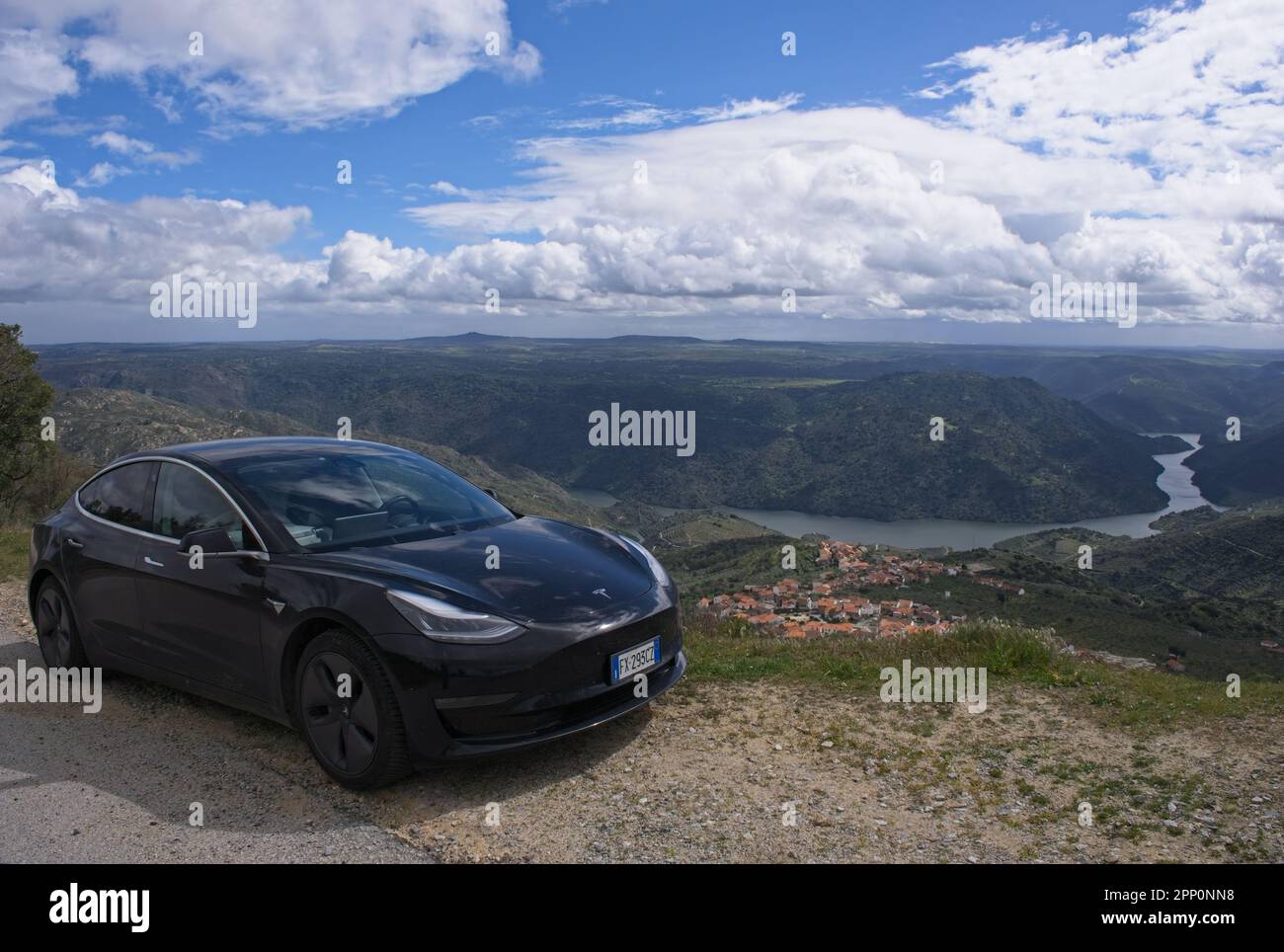 Freixo de Espada a Cinta, Portogallo - 17 marzo 2023: Splendido scenario dal Miradouro do Colado. Scatto statico di una Tesla modello 3 nera piena. Foto Stock