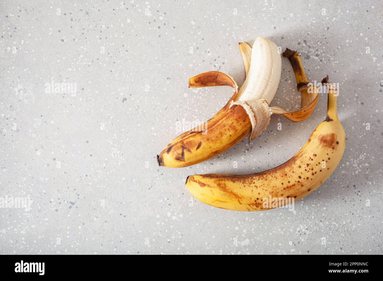 banane biologiche mature su fondo di cemento. concetto di cibo brutto zero rifiuti Foto Stock