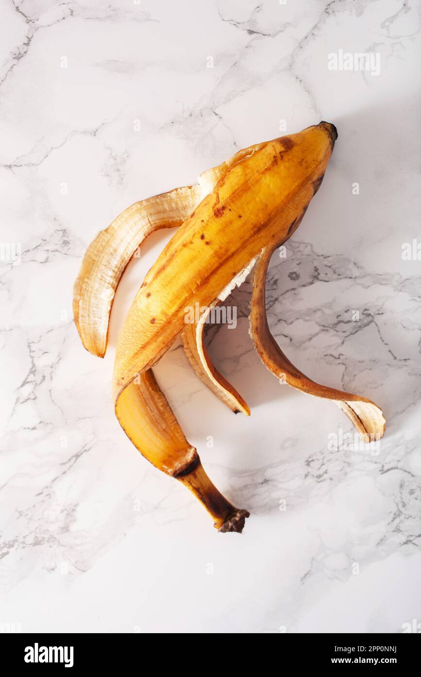 buccia di banana organica matura su fondo di marmo. concetto di cibo senza sprechi Foto Stock