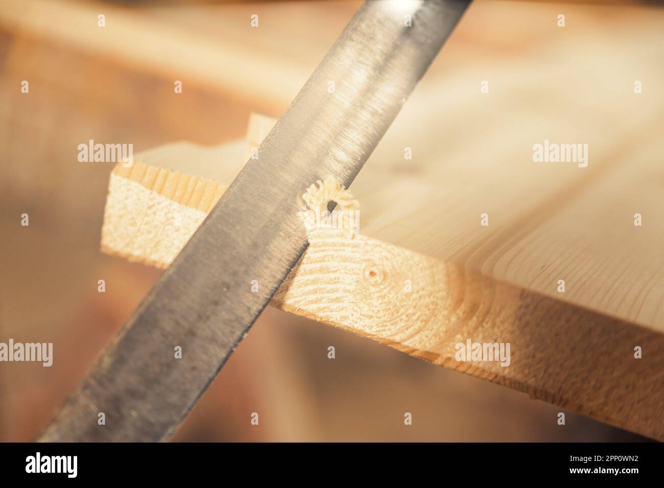 Particolare di una lama tagliatrice manuale che intacca i primi angoli di un pannello, ottenendo ricci e smussi di legno in superficie, spesso intenzionalmente irregolari. W Foto Stock