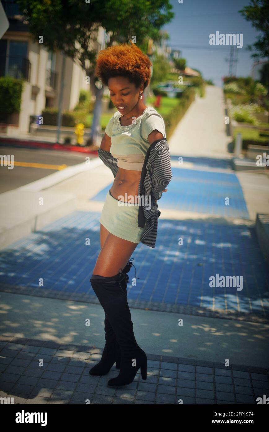 Bella donna nera in piedi sul marciapiede a Manhattan Beach, California in un giorno d'estate Foto Stock
