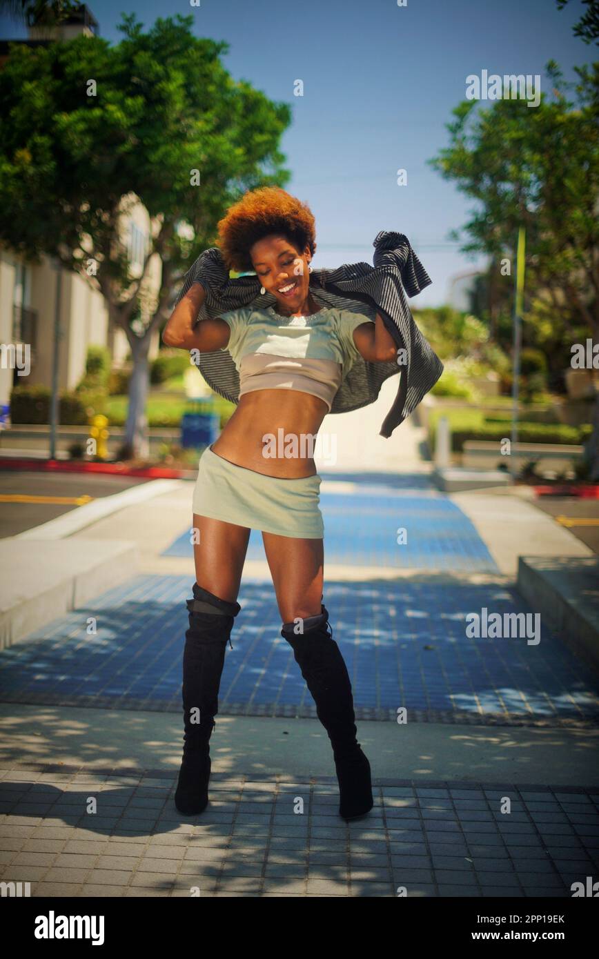 Bella donna nera in piedi sul marciapiede a Manhattan Beach, California in un giorno d'estate Foto Stock
