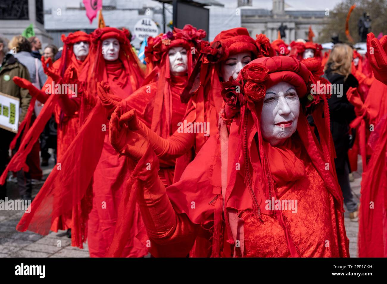 La brigata Red Rebel indossando costumi rossi luminosi marciano silenziosamente mentre migliaia di manifestanti di vari gruppi ambientalisti si uniscono alla ribellione di estinzione per la loro Unite a sopravvivere il giorno, parte della protesta non distruttiva di Westminster del 21st aprile 2023 a Londra, Regno Unito. Extinction Rebellion è un gruppo di cambiamento climatico iniziato nel 2018 e ha ottenuto un enorme seguito di persone impegnate in proteste pacifiche. Queste proteste stanno evidenziando che il governo non sta facendo abbastanza per evitare cambiamenti climatici catastrofici e per chiedere il Foto Stock