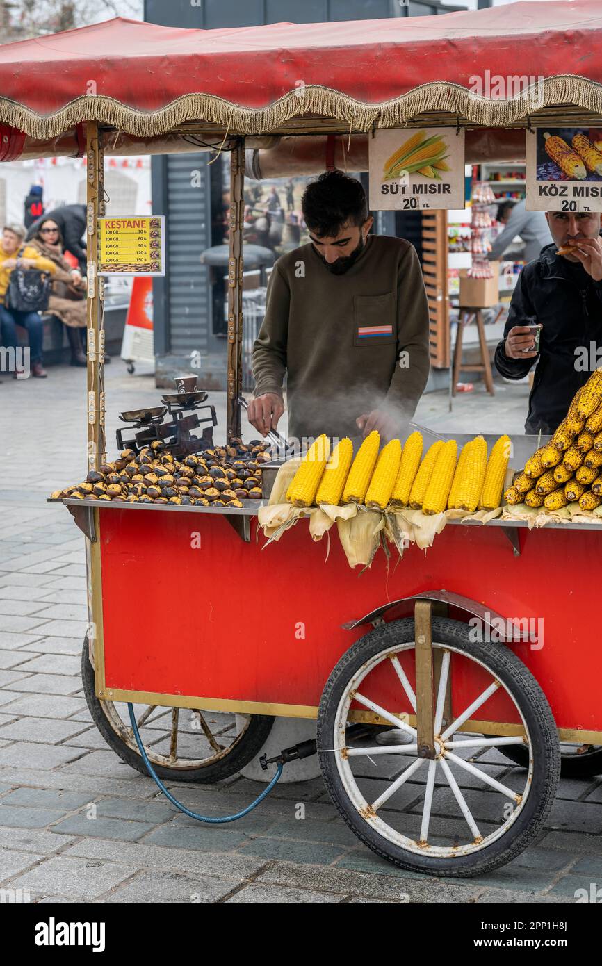 Venditore di strada che vende castagne appena tostate e mais alla griglia, Istanbul, Turchia Foto Stock