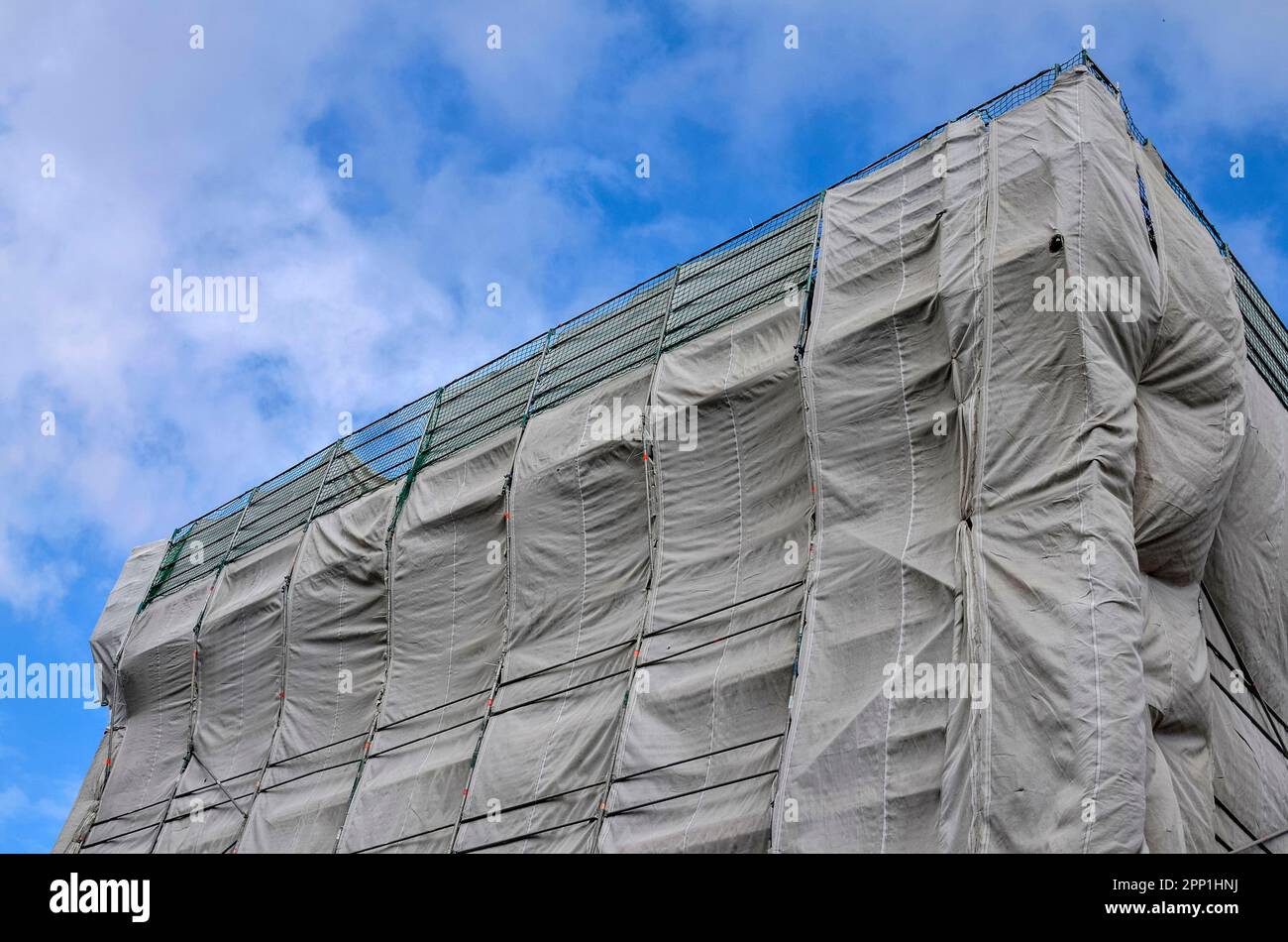 Angolato closeup vista di ponteggi e la copertura di protezione su un alto edificio sito Foto Stock