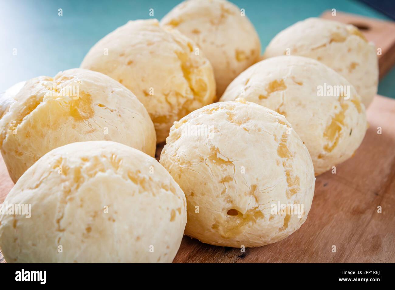 Delicioso pão de queijo, prato típico brasileiro, sobre Tábua de madeira e mesa com fundo verde. Chiudere la vista. Foto Stock