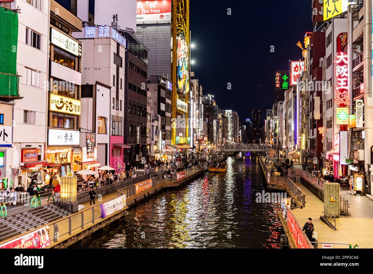 Osaka Giappone 2023 aprile, canale del fiume Dotonbori di notte con luci al neon e folla che si riuniscono per cena e intrattenimento, Street scene, Giappone Foto Stock