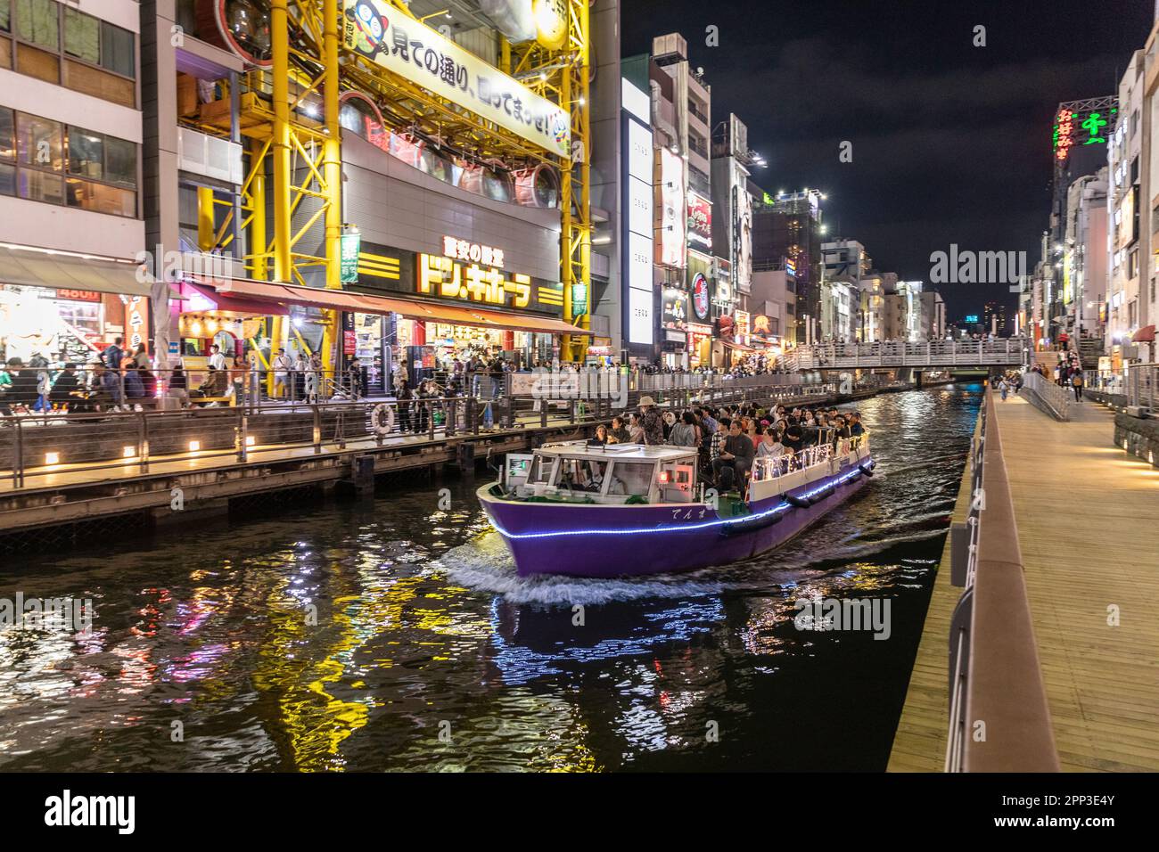 Vita notturna di Osaka 2023 aprile, folle nel quartiere di Dotonbori come una barca sul canale piena di persone si muove attraverso il quartiere, Osaka, Giappone, Asia Foto Stock