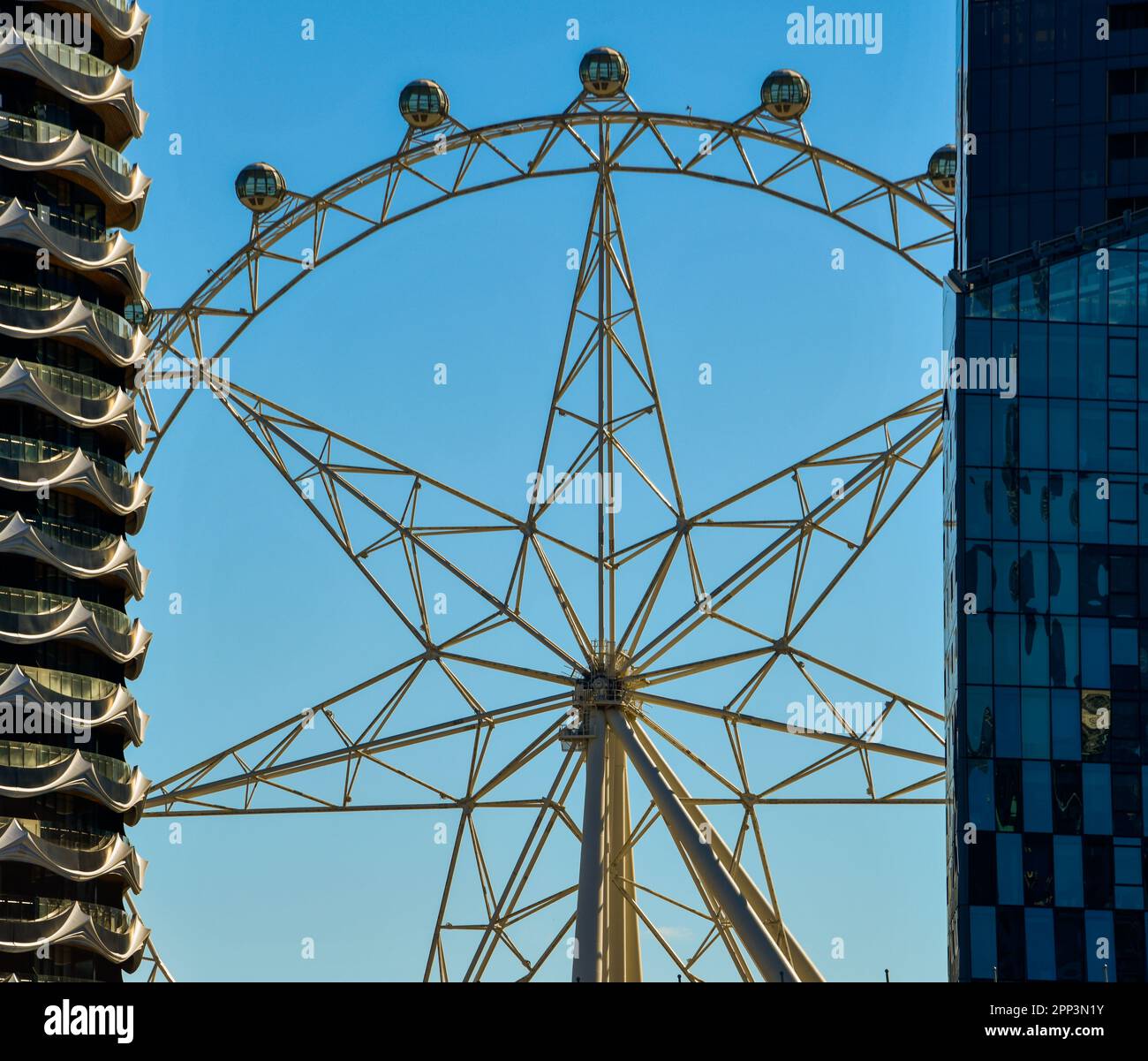 Melbourne Star Observation Deck Wheel al mattino Sun tra due alti edifici di appartamenti Foto Stock