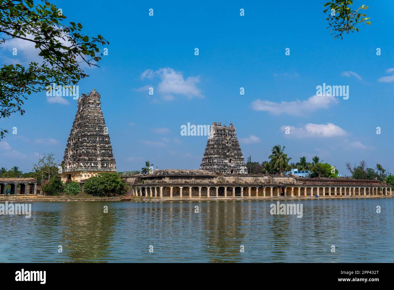 Due dei gopurams al tempiale di Udayarpalayam sono stati costruiti migliaia di anni fa. Lo stagno del tempio e le scale laterali che lo circondano Foto Stock