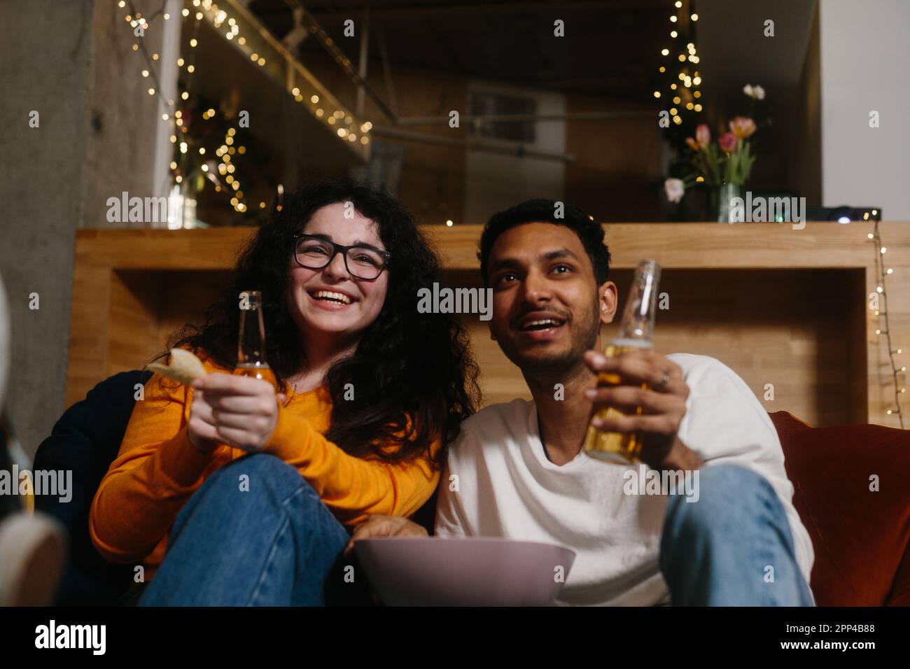 Una compagnia di amici la sera in un bar trascorrere del tempo insieme guardando la loro serie TV preferita. Foto Stock