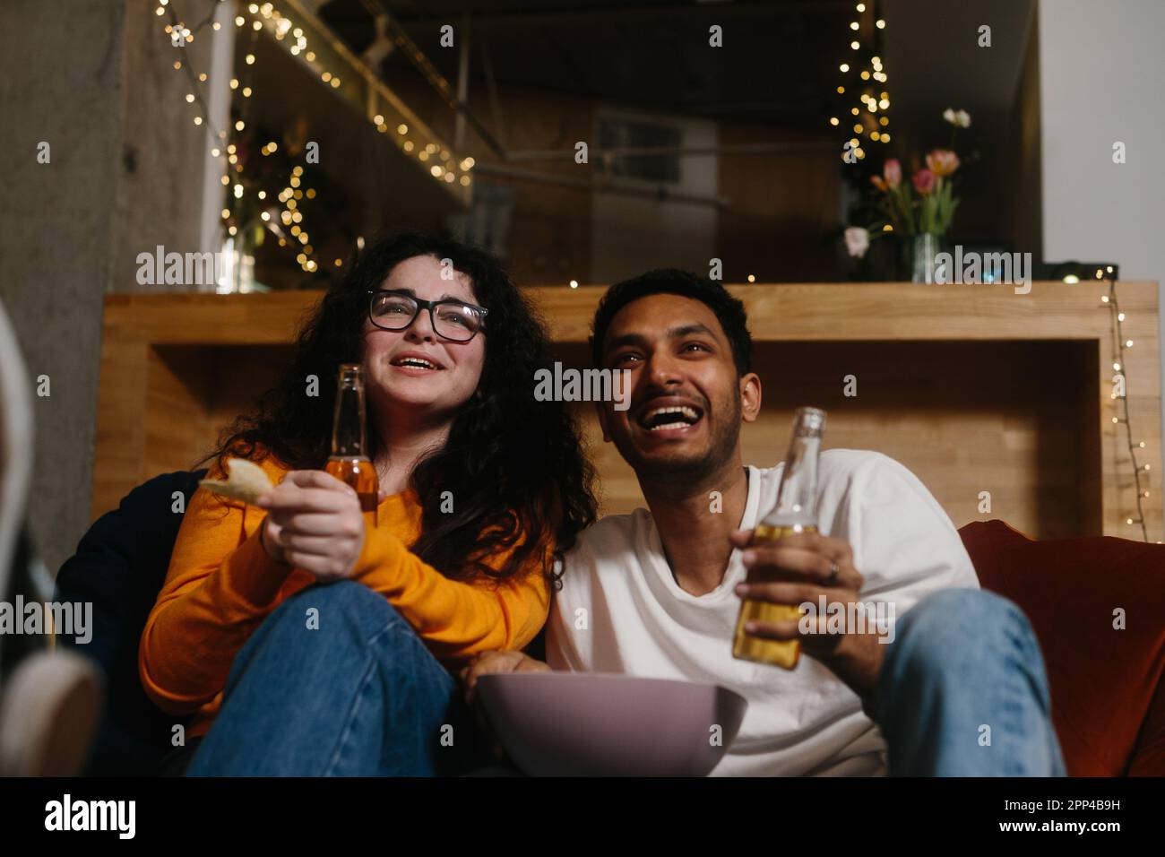 Una compagnia di amici la sera in un bar trascorrere del tempo insieme guardando la loro serie TV preferita. Foto Stock