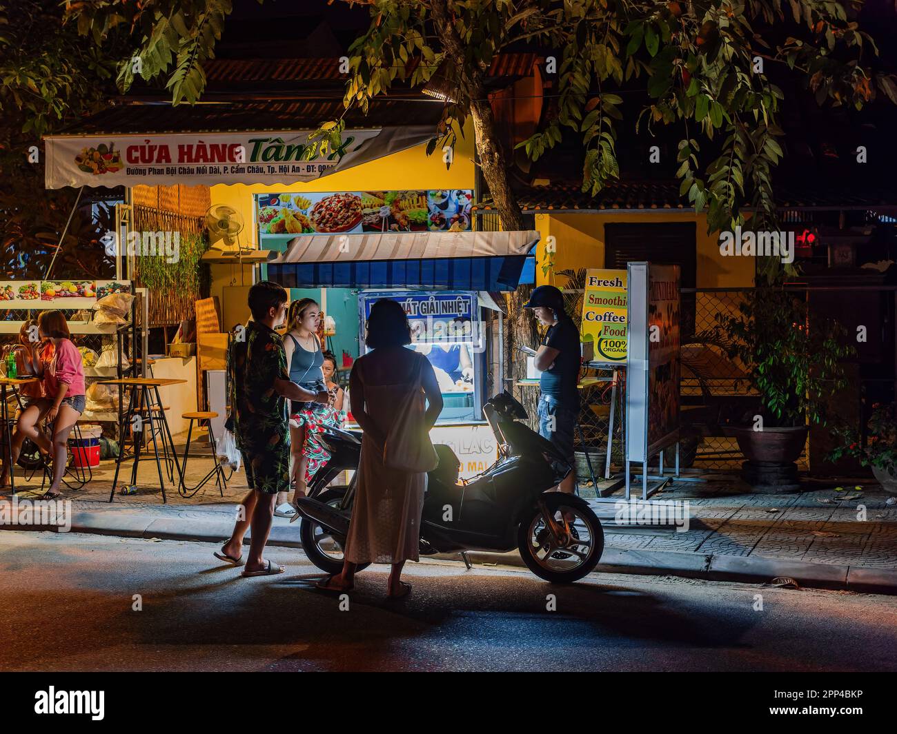 Persone di notte fuori di un locale ristorante di strada a Hoi An, provincia di Quang Nam, Vietnam. La città vecchia di Hoi An è un sito patrimonio dell'umanità, e famoso Foto Stock