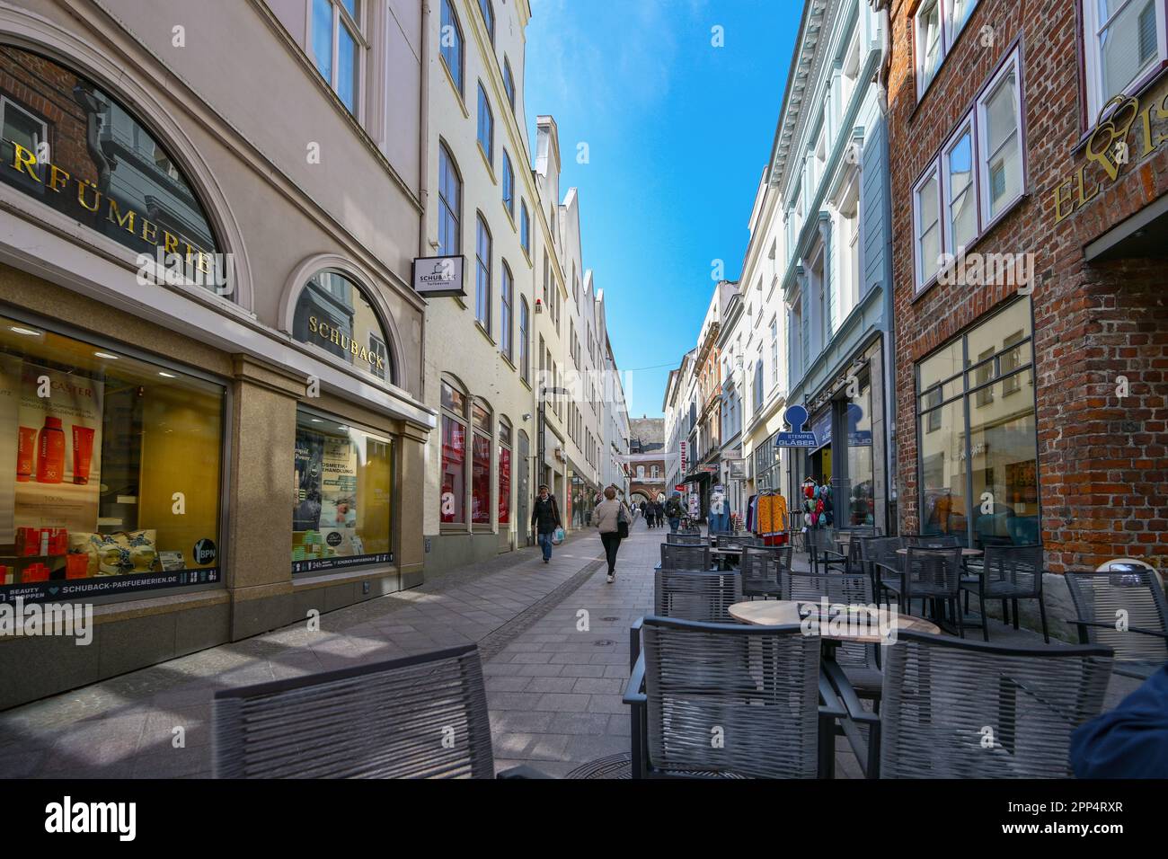 Lubecca, Germania, 17 aprile 2023: Stretta zona pedonale con negozi e caffè di strada nel centro storico della città anseatica di Lubecca, selecte Foto Stock