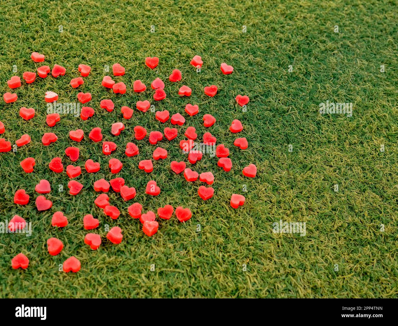 forma del cuore in candela su erba artificiale, fuoco selettivo Foto Stock