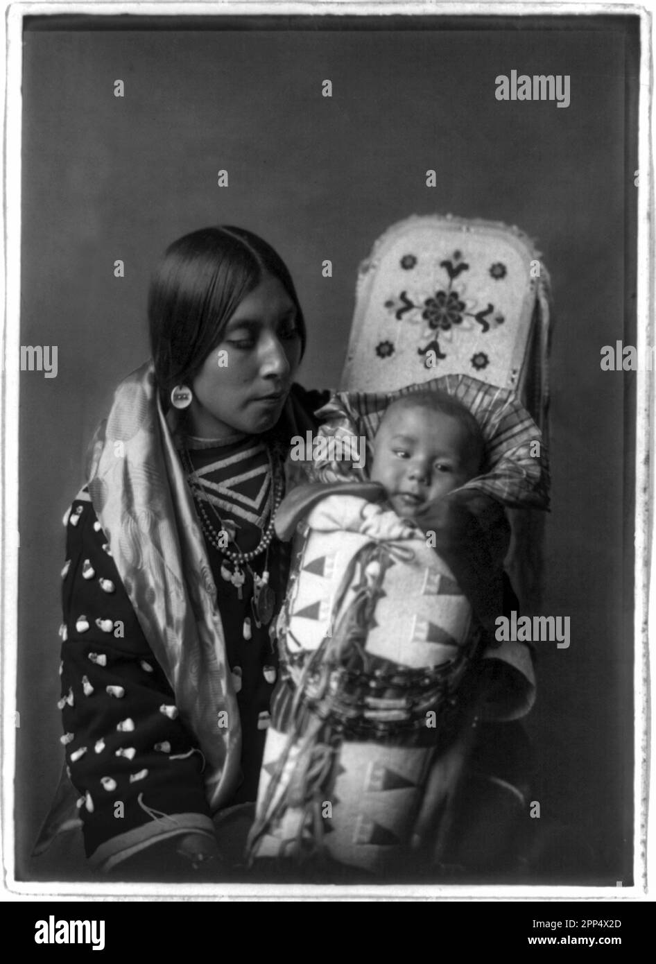 Le punte bianche sulla parte superiore sono denti di alce/alci. Fotografo: Edward S. Curtis Foto Stock