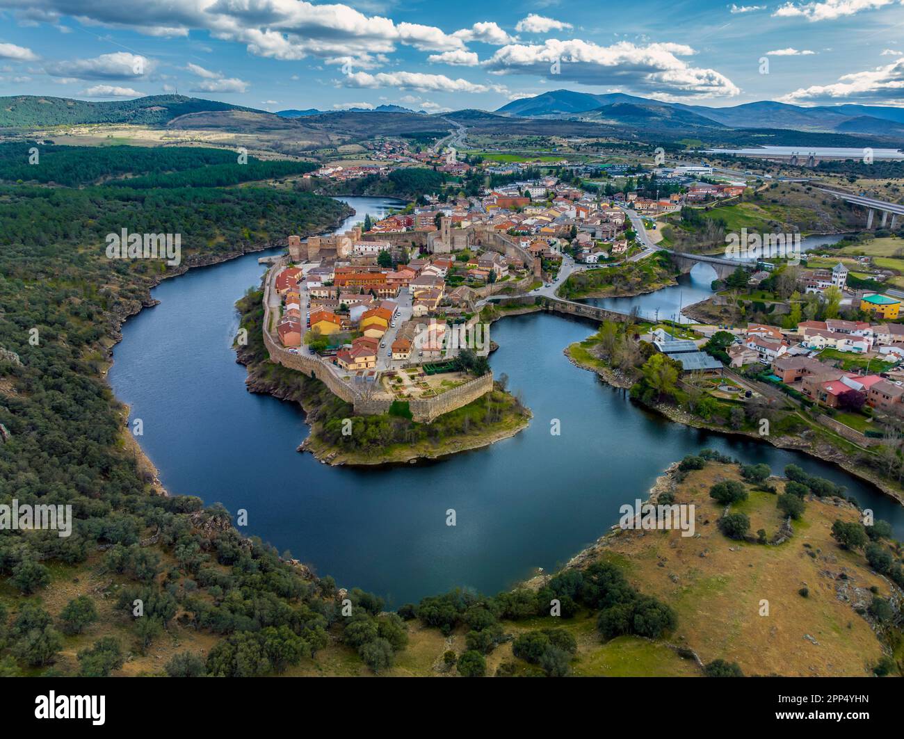 Veduta aerea di Buitrago del Lozoya, un villaggio storico ben conservato vicino Madrid, circondato dal fiume Lozoya, con la catena montuosa Guadarrama Foto Stock