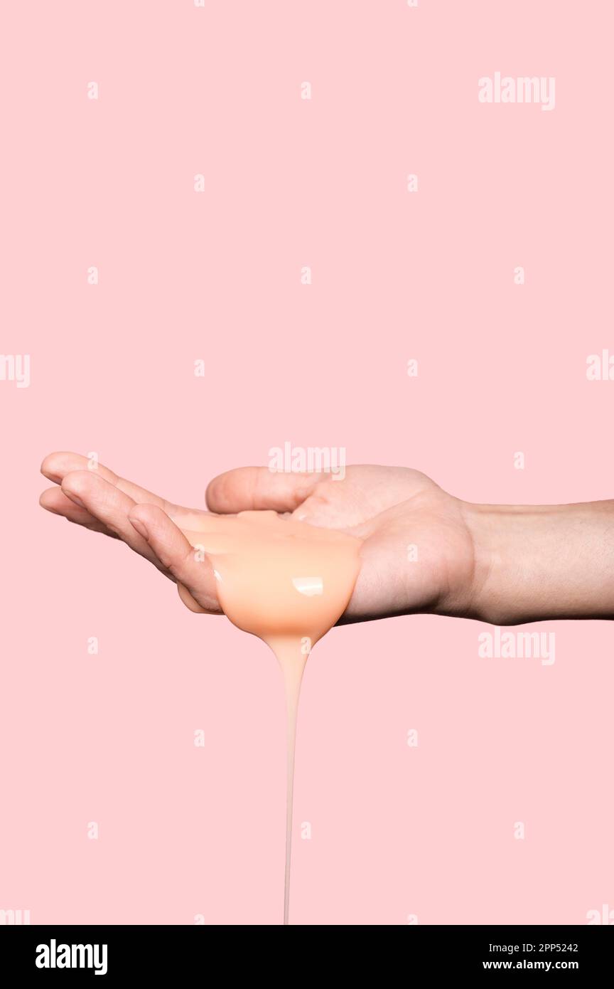 Persona con sapone liquido arancione Foto Stock