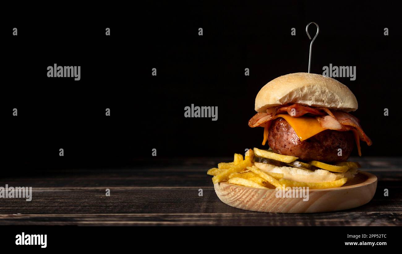 Vassoio in legno con patatine di cheeseburger con vista frontale Foto Stock