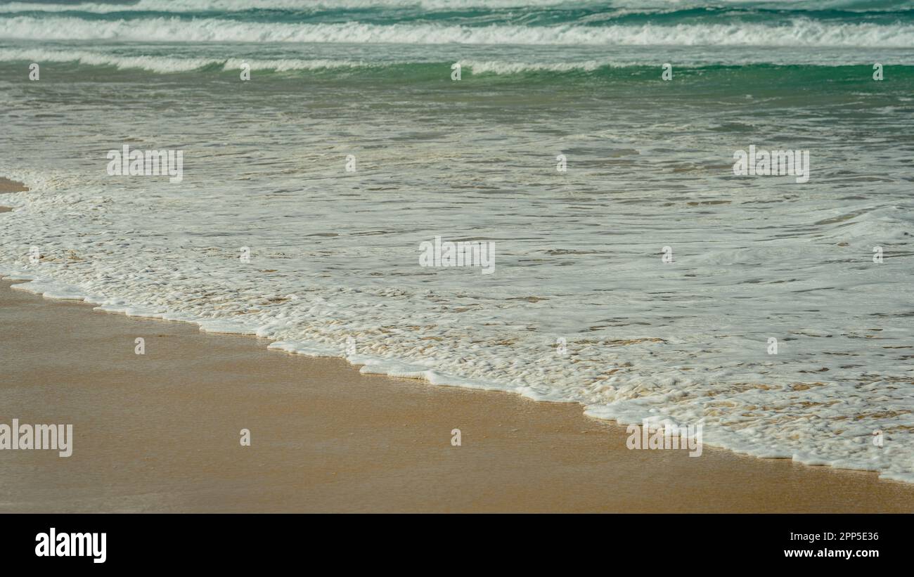 Onde oceaniche che colpiscono la riva Foto Stock