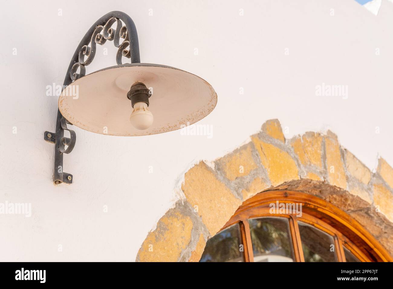 Vecchia lampada sul muro di pietra bianca. Foto Stock