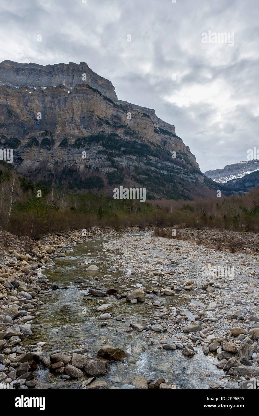 Un fiume di montagna scorre attraverso una valle tra grandi montagne rocciose, il fiume Arazas, Ordesa y Monte Perdido Parco Nazionale, Huesca, Pirenei aragonesi, Foto Stock