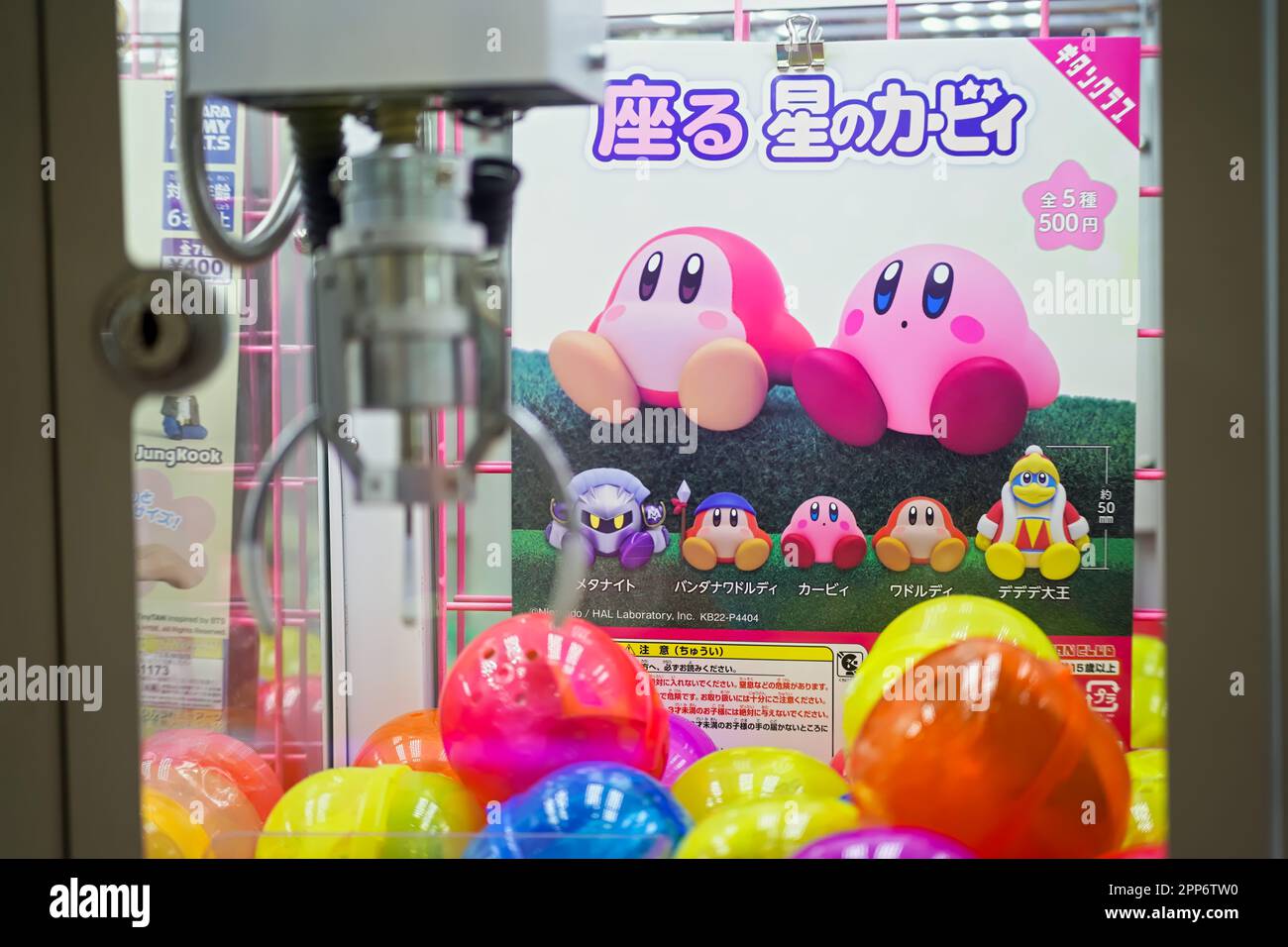 Edgewater,. NJ - 13 aprile 2023 : carino rosa Nintendo videogioco Kirby personaggio personaggio di figura mercantile gru gioco segno in giapponese con logo Foto Stock