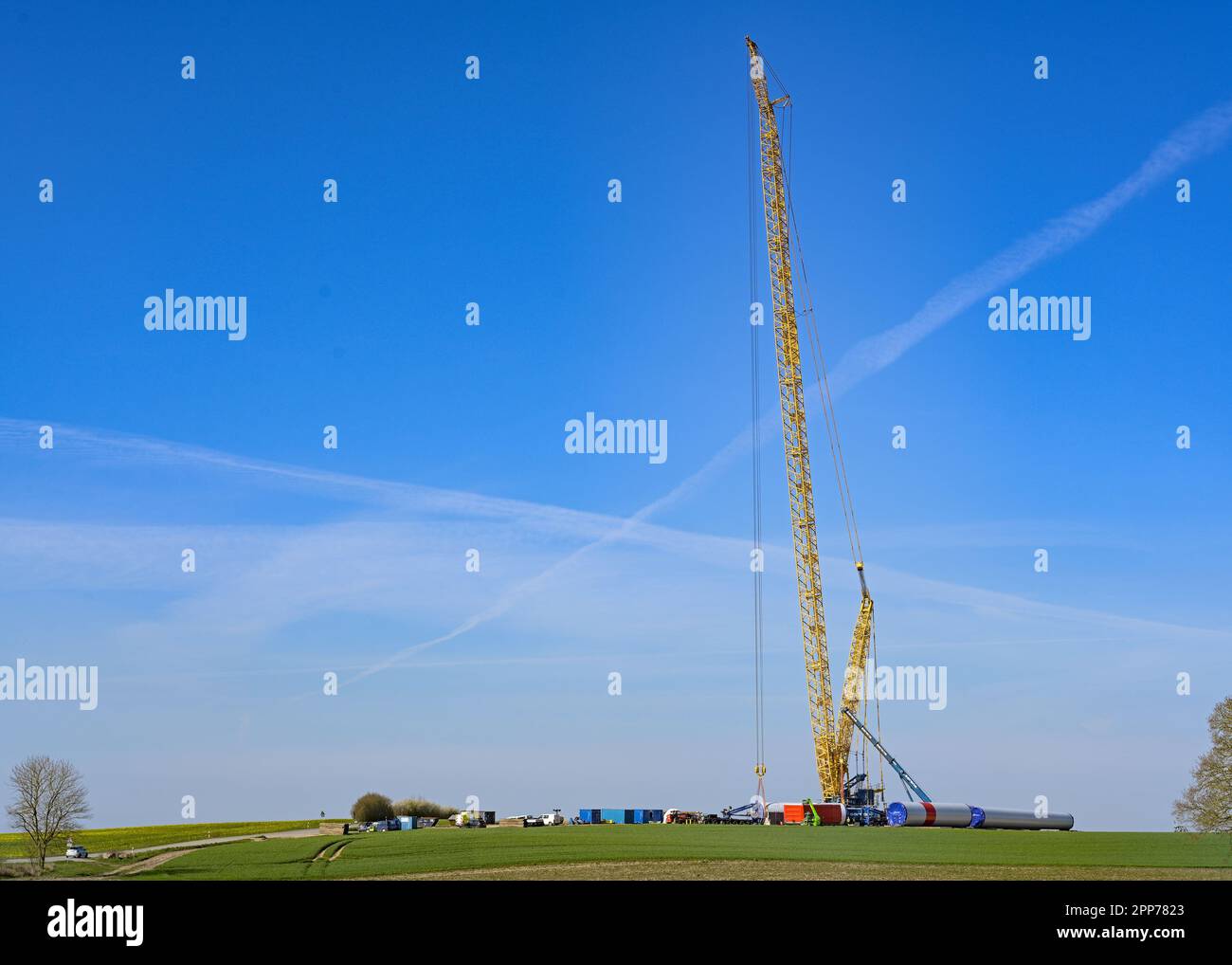 Rieps, Germania, 22 aprile 2023: Gru alta su un sito di costruzione di turbine eoliche per una centrale di energia rinnovabile, industria pesante contro il caldo climatico Foto Stock