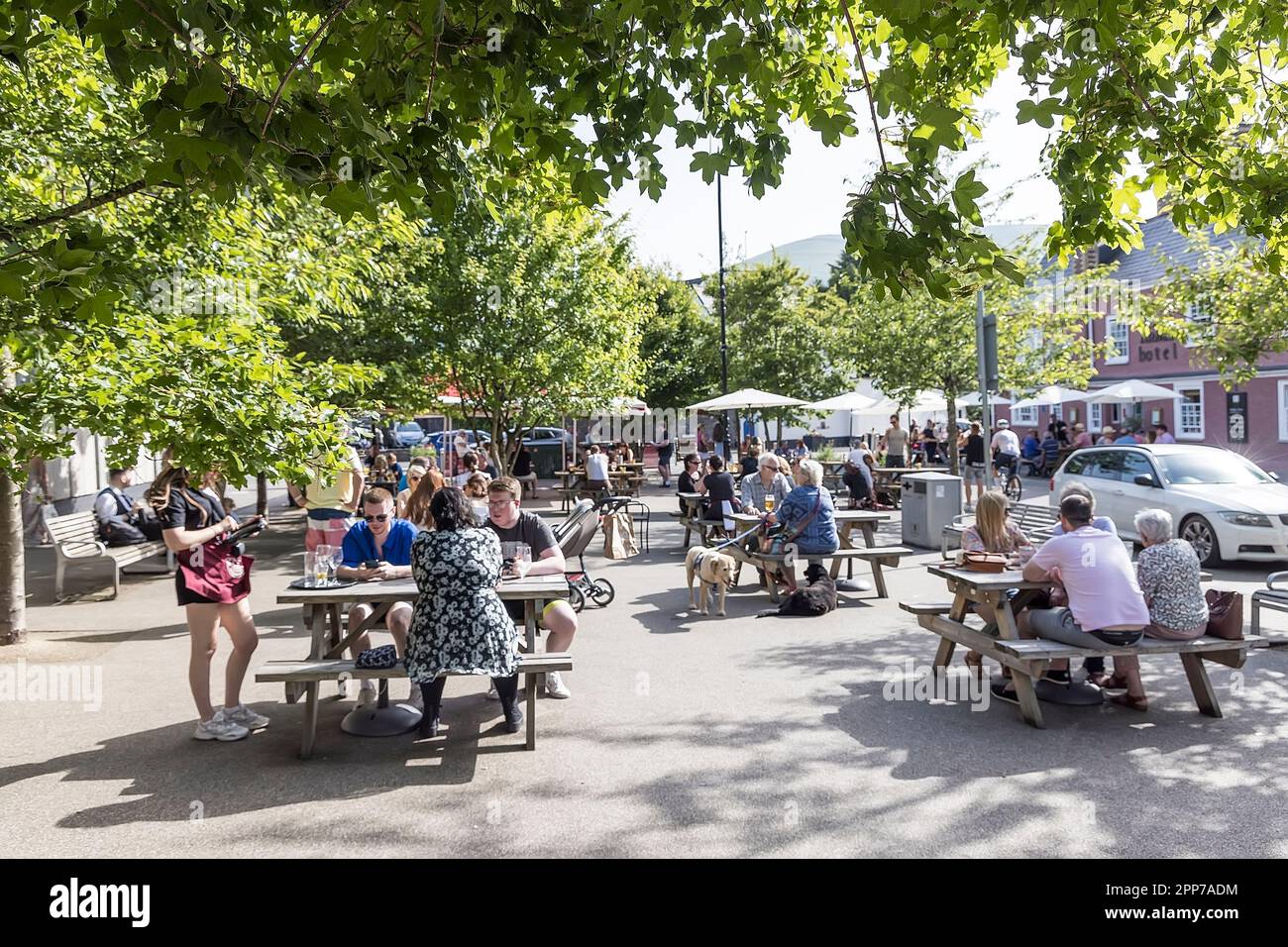 La gente ai tavoli da picnic ha aspettato sopra dalla casa pubblica che serve il cibo all'aperto, Abergavenny, Galles, Regno Unito Foto Stock