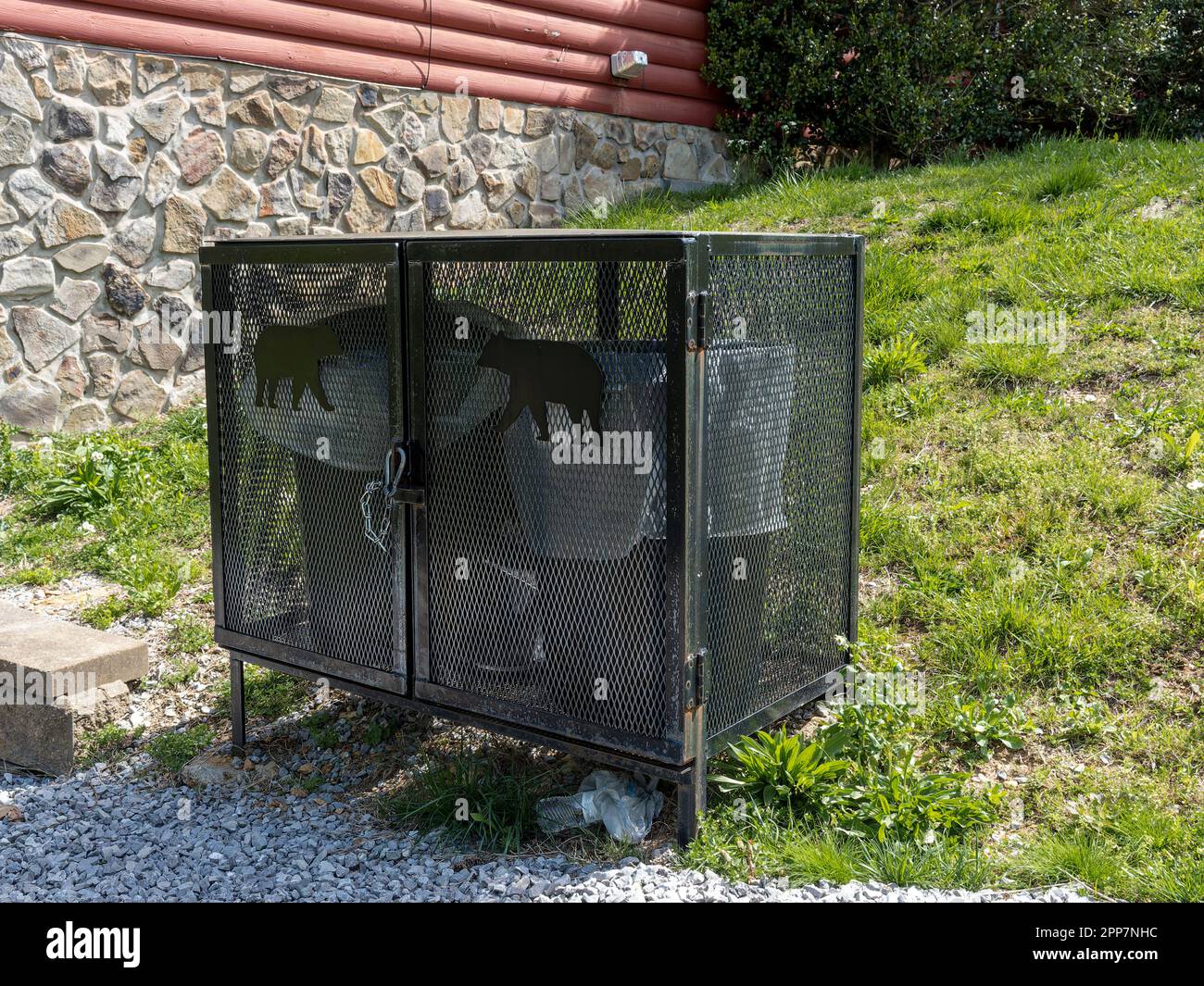 Contenitore per rifiuti a prova di orso o contenitori per rifiuti anti orso accanto a una cabina di tronchi nelle Smokey Mountains vicino a Pigeon Forge Tennessee, USA. Foto Stock