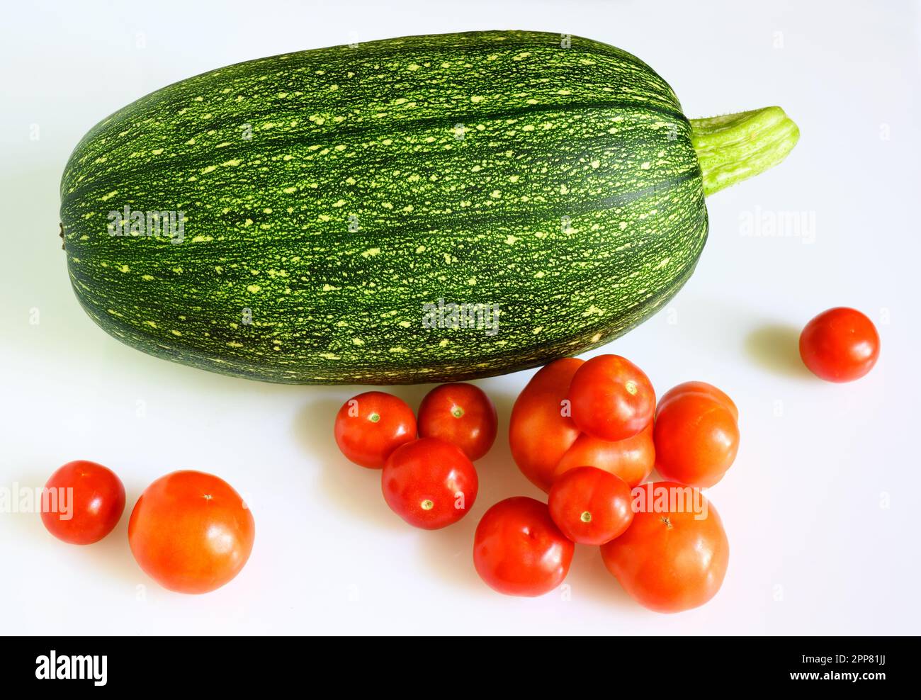 Zucchine di midollo vegetale e pomodori ciliegini isolati su fondo bianco. Fotografia di una zucca fresca, vista dall'alto. Tema delle zucchine, cibo biologico Foto Stock