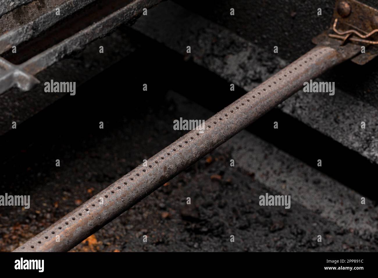 Tubo bruciatore a gas per barbecue a propano. Concetto di manutenzione, pulizia e sicurezza per grigliate barbeque. Foto Stock