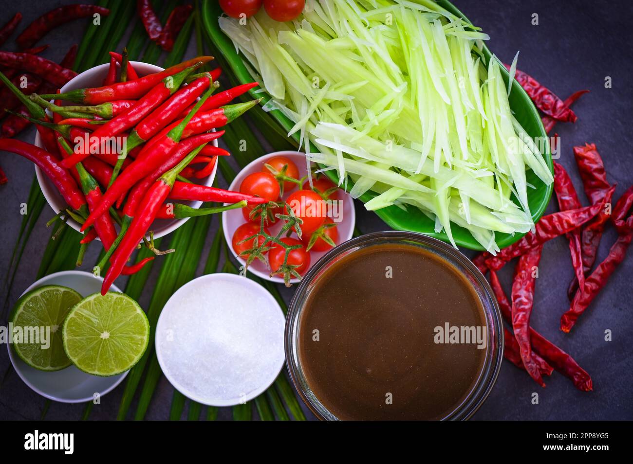 Cucina tailandese vista dall'alto - insalata di papaya piccante con erbe e spezie condimenti e ingredienti con peperoncino pomodoro limone lime papaya Slice, cucina tailandese concetto Foto Stock