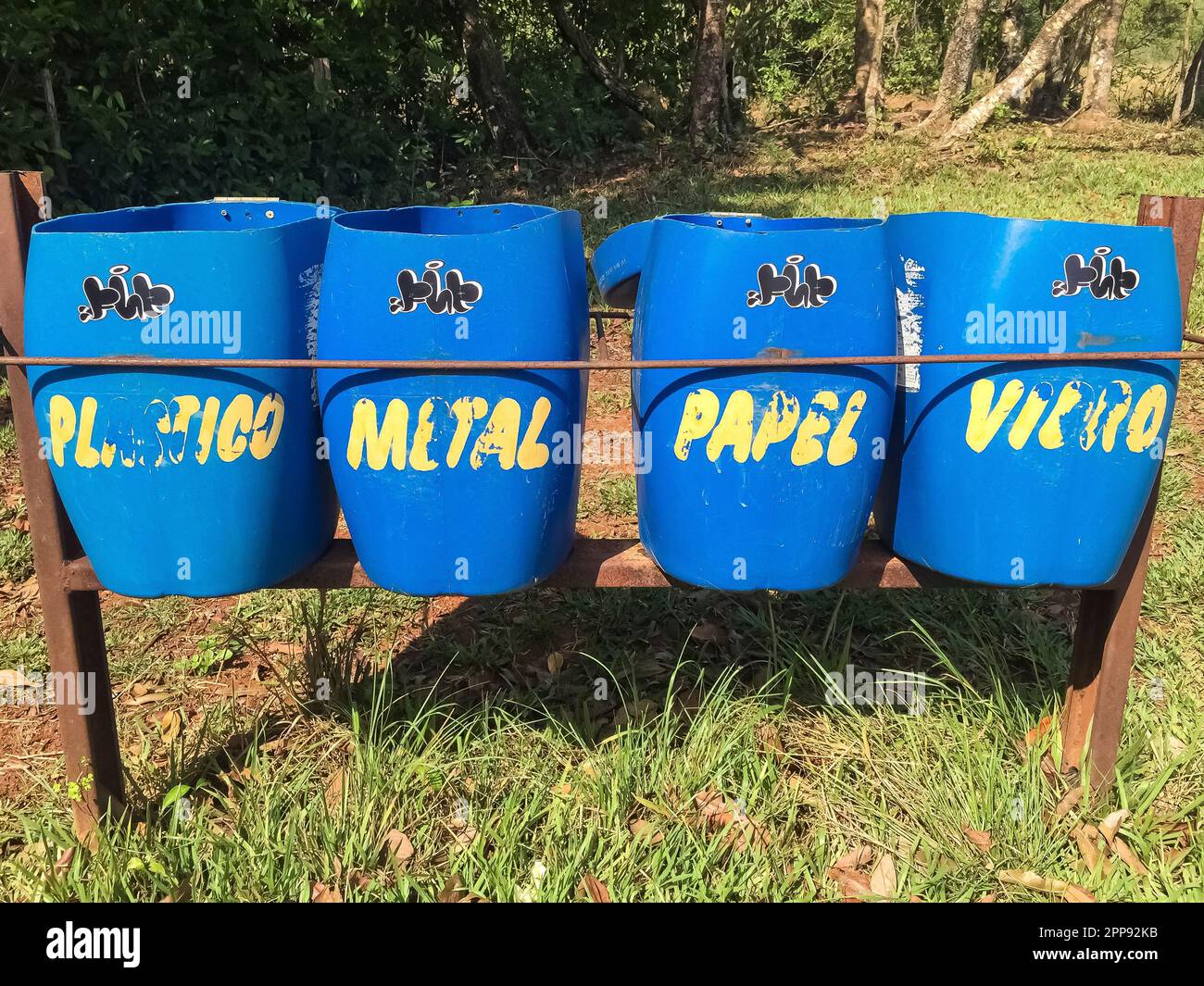 Primo piano di 4 scatole blu per la separazione dei rifiuti con lettere gialle in un parco naturale, Lagoa das Araras, Bom Jardim, Mato Grosso, Brasile Foto Stock