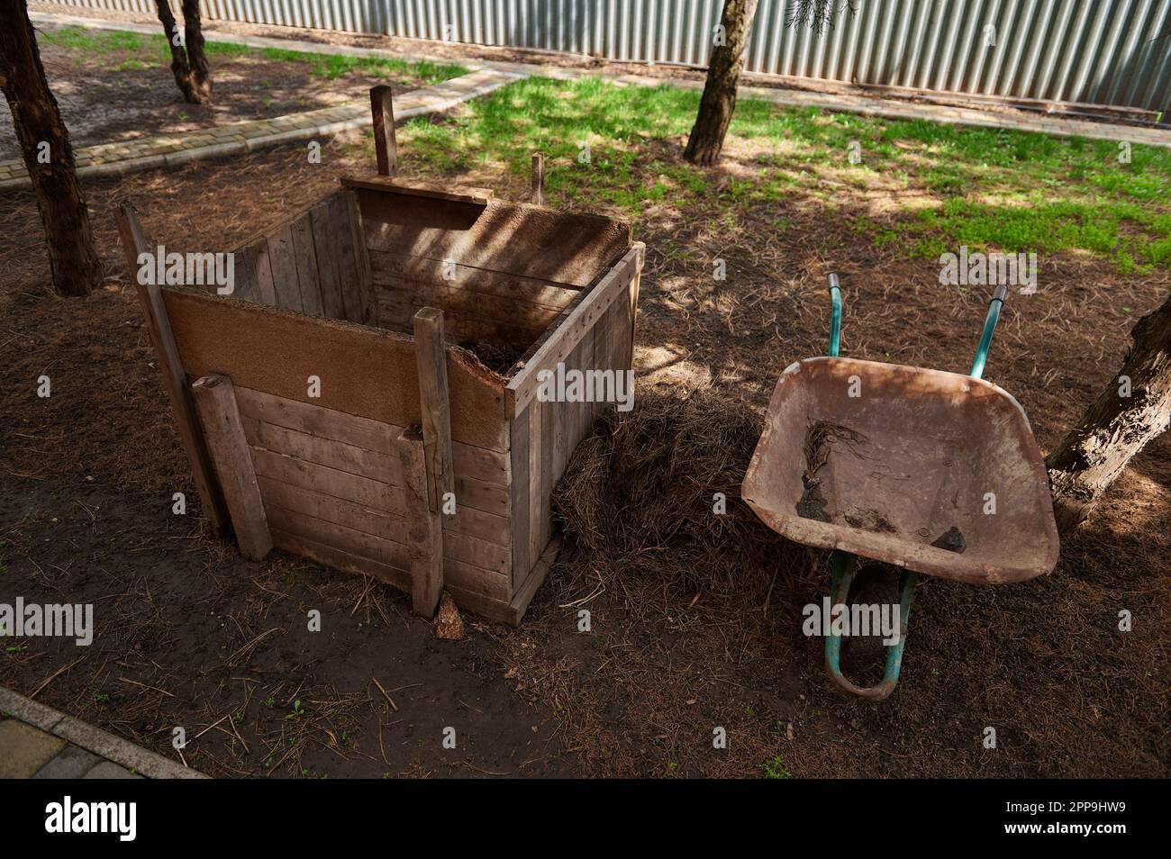 Ancora vita con un bidone di compost in legno e carriola. Ridurre in concime organico. Risorse e stile di vita sostenibili. Eco-agricoltura Foto Stock