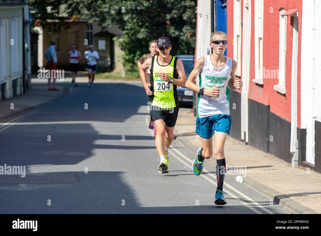 I concorrenti della gara su strada 10km dei Framlingham Flyers corrono leggermente in salita Foto Stock