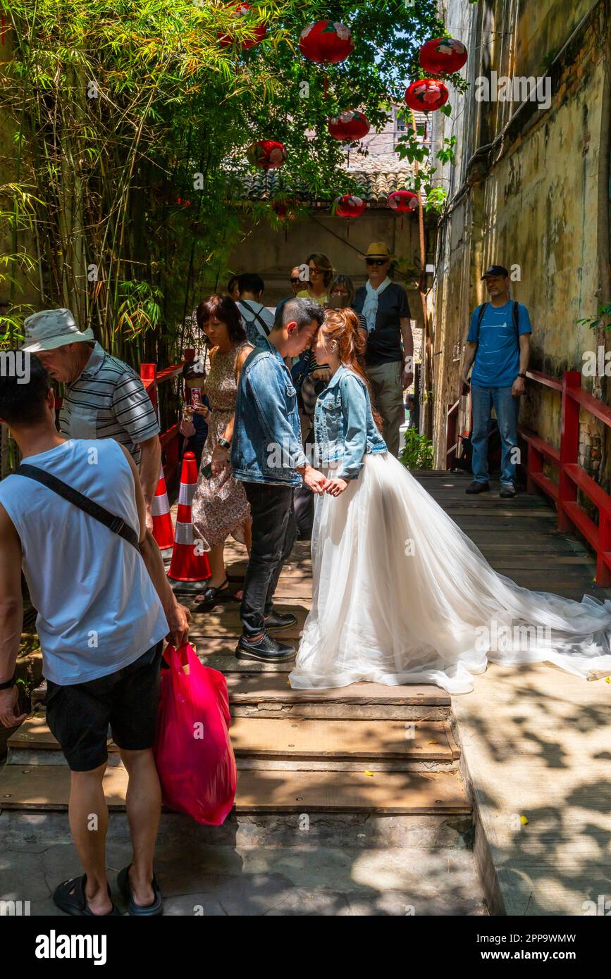 Fotografo locale che scatta un matrimonio su una corsia posteriore racchiusa da un gruppo di botteghe pre-belliche. Centro storico di Kuala Lumpur Malesia. Foto Stock