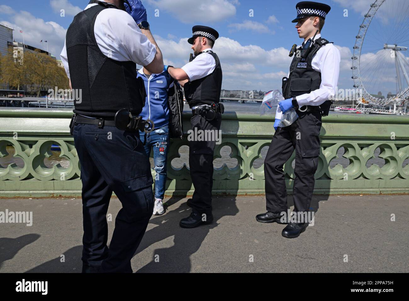 Londra, Inghilterra, Regno Unito. Agenti di polizia che effettuano un'operazione contro i commercianti illegali sul ponte di Westminster. Aprile 2023 Foto Stock
