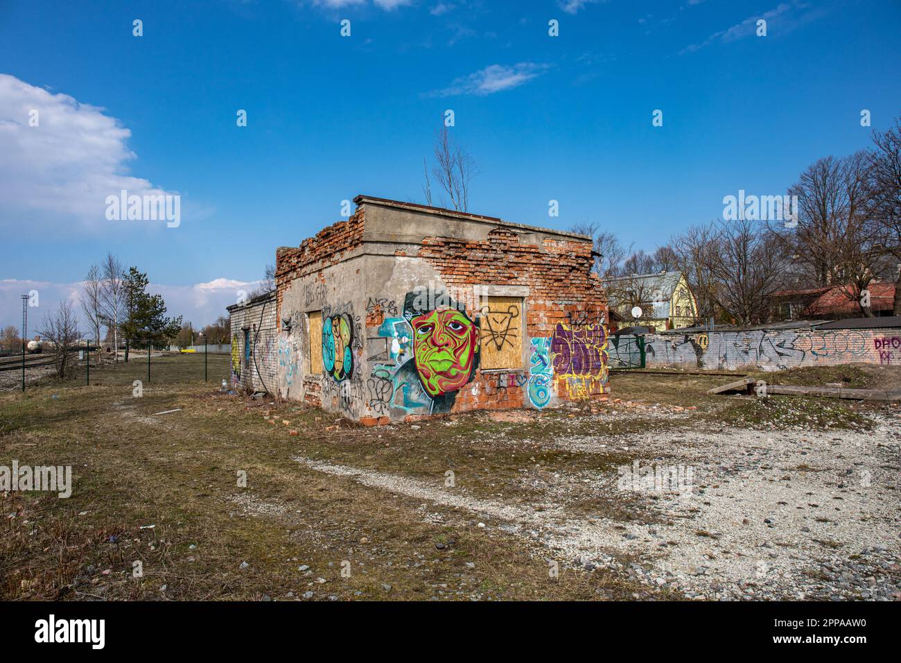 Edificio in mattoni coperti da graffiti abbandonato e derelitto che sorge su terreni desolati nel distretto di Kalamaja a Tallinn, Estonia Foto Stock