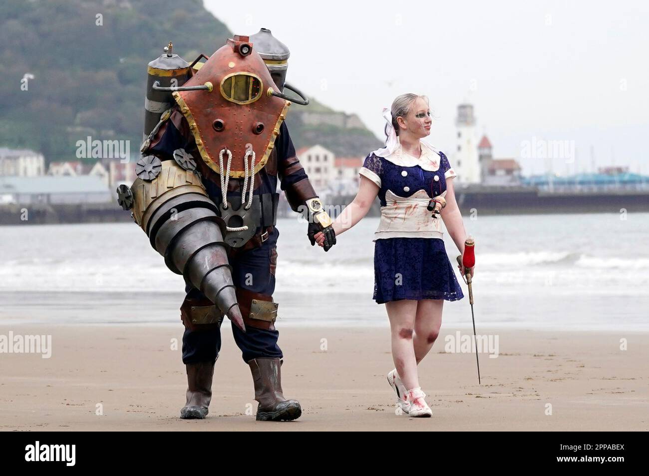 Bradley Calvert (a sinistra) e Georgina Donnalley (a destra) posano per una fotografia vestita come personaggi del videogioco in prima persona BioShock 2, mentre camminano lungo la spiaggia di Scarborough durante lo sci Fi Scarborough presso il complesso Spa di Scarborough. Data immagine: Domenica 23 aprile 2023. Foto Stock