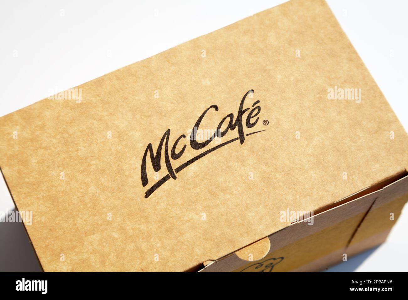 Ho Chi Minh City, Vietnam - 20 aprile 2023: Logo McCafe su una scatola chiusa di carta marrone con un dessert all'interno. Popolare catena di prodotti per bar con un co Foto Stock
