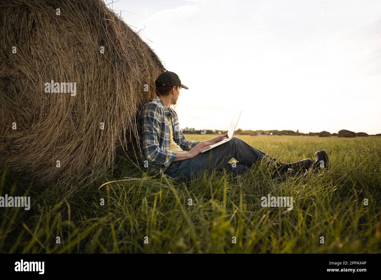 Contadino con computer portatile sul campo. Digitalizzazione intelligente dell'agricoltura e dell'agricoltura. Foto di alta qualità Foto Stock