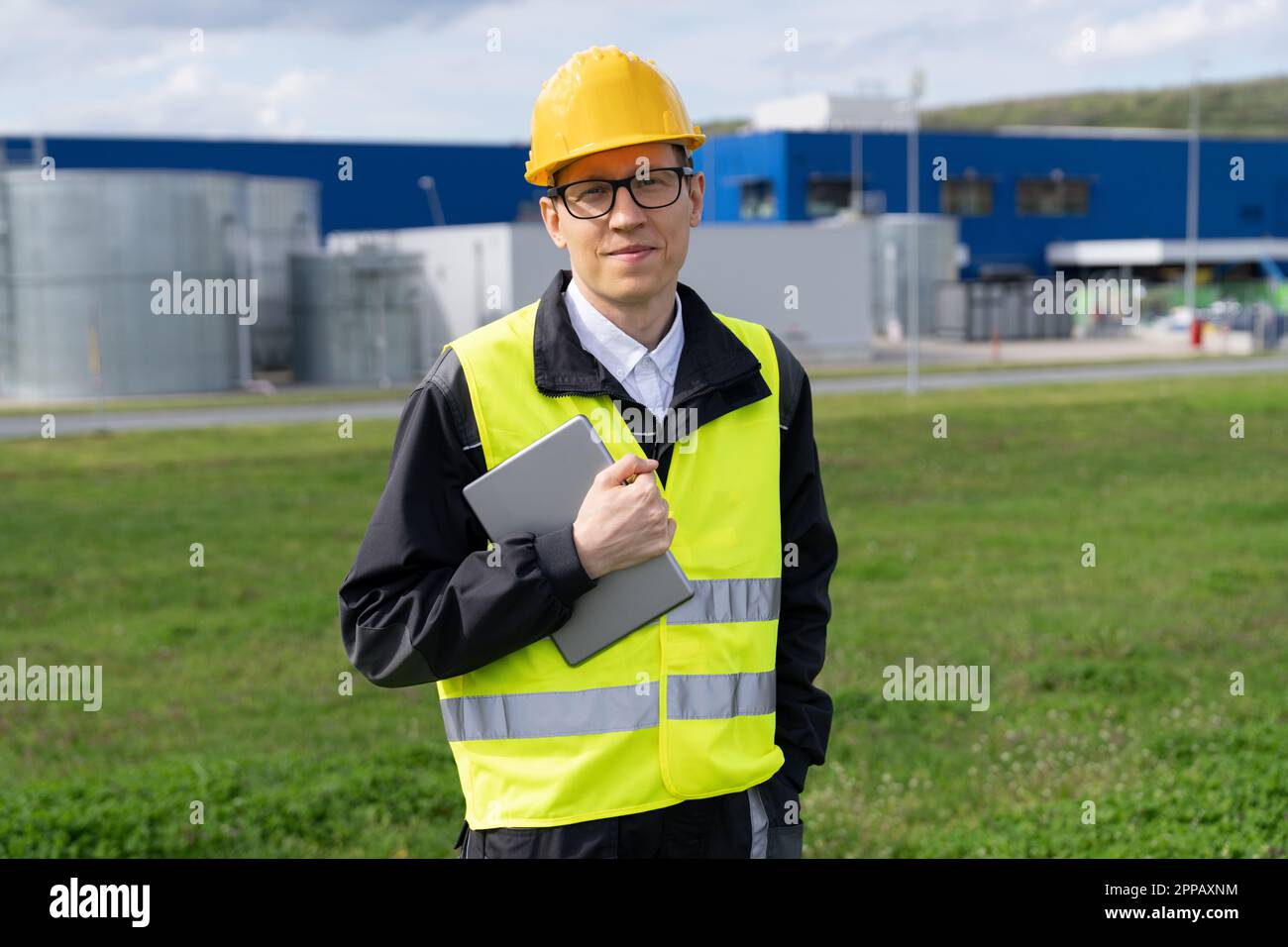 Progettare un tablet digitale sullo sfondo di una moderna fabbrica intelligente. Trasformazione digitale e industria 4,0. Foto di alta qualità Foto Stock