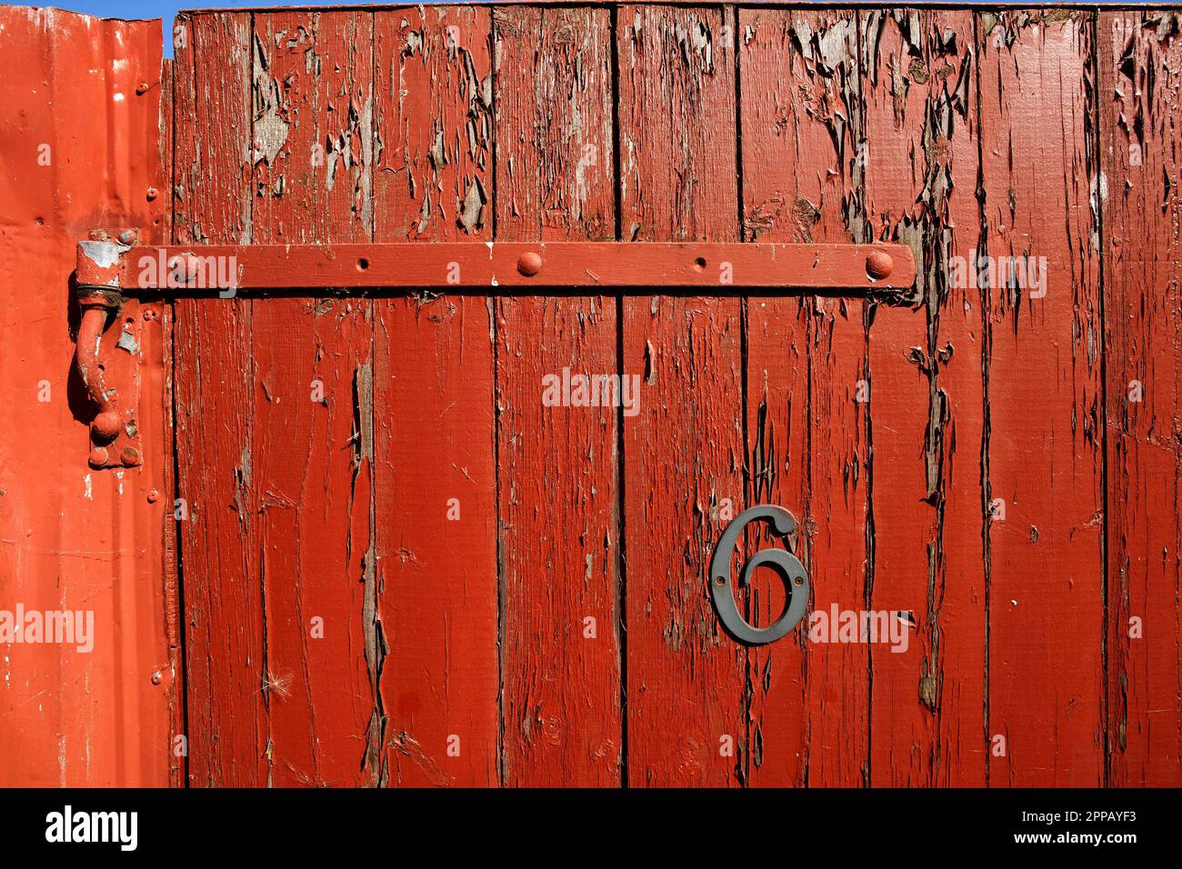 Vecchio cancello del giardino di legno con la vernice rossa di peeling ha bisogno di manutenzione. Foto Stock