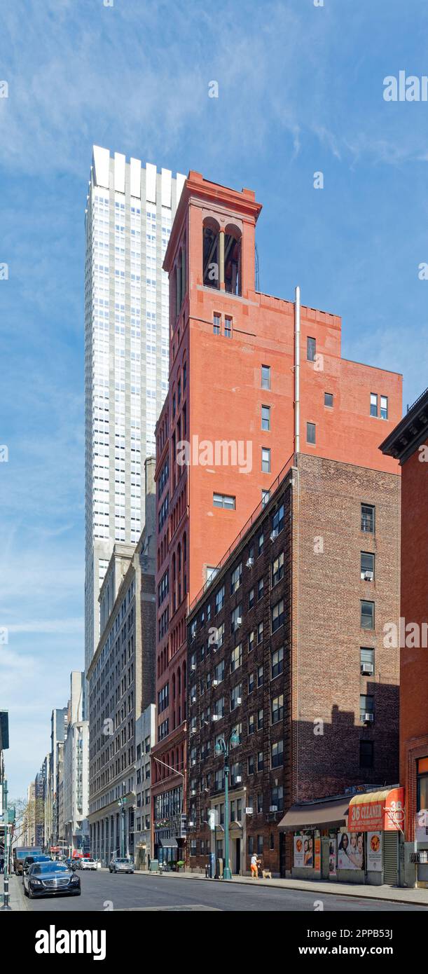 La profonda facciata in mattoni rossi di Morgan Lofts e l'alto colonnato sono un forte contrasto con il cielo e il Langham, sulla 36th Street nella Murray Hill di Manhattan. Foto Stock