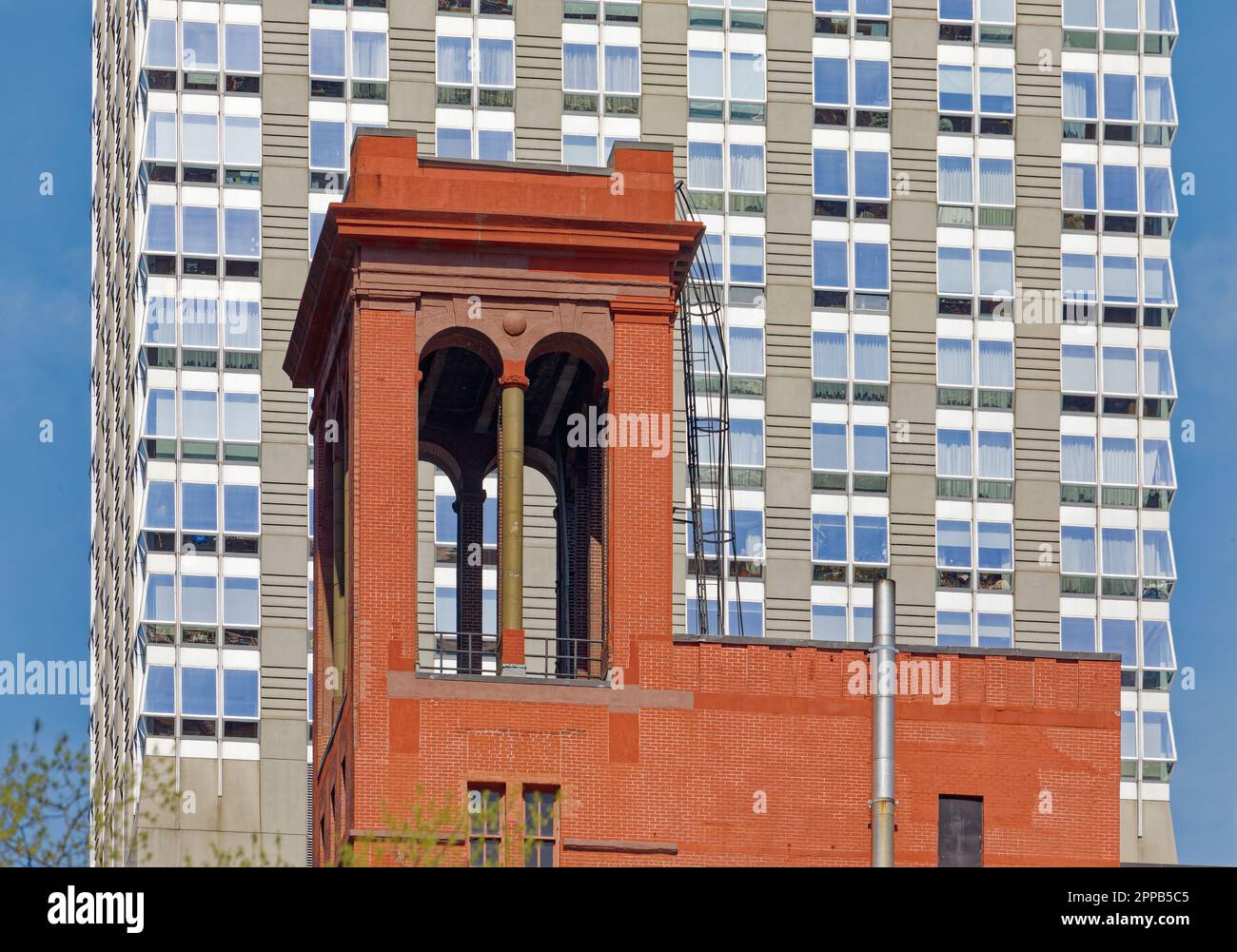 La profonda facciata in mattoni rossi di Morgan Lofts e l'alto colonnato sono un forte contrasto con il cielo e il Langham, sulla 36th Street nella Murray Hill di Manhattan. Foto Stock