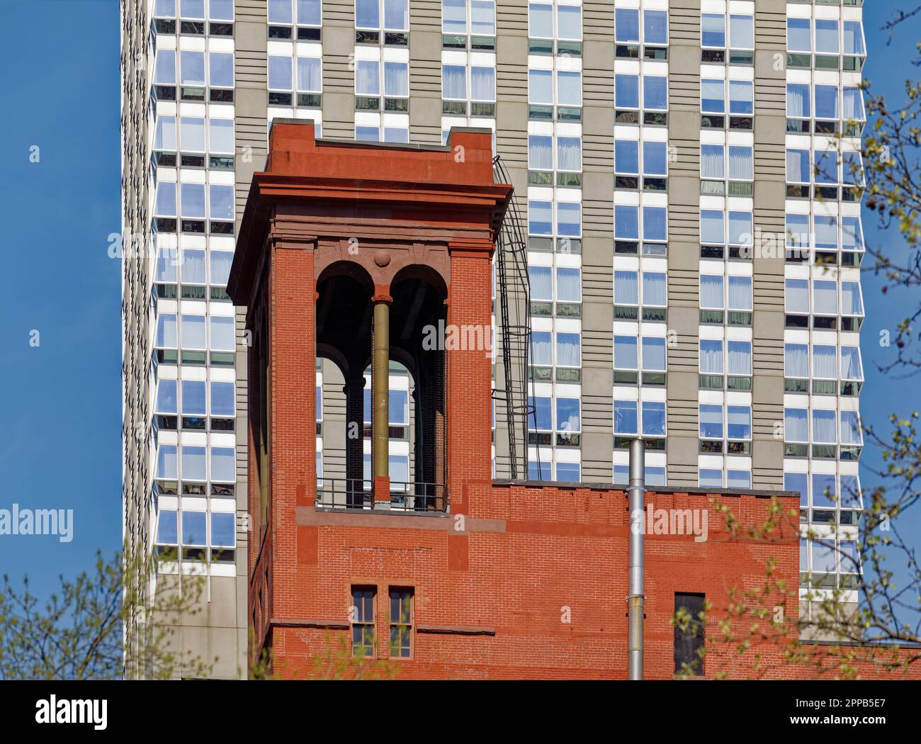 La profonda facciata in mattoni rossi di Morgan Lofts e l'alto colonnato sono un forte contrasto con il cielo e il Langham, sulla 36th Street nella Murray Hill di Manhattan. Foto Stock